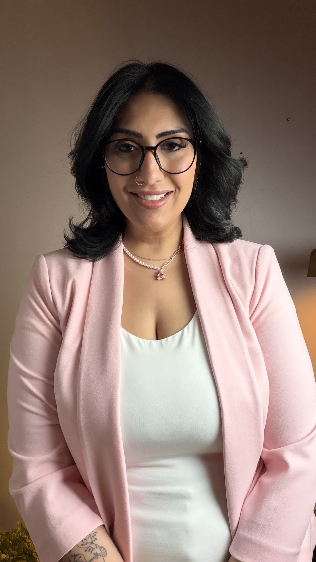 Rubina K. Singh in a pink blazer, smiling at the camera